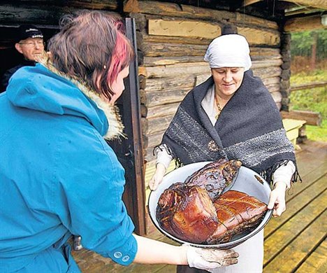 25 KILO DELIKATESSI: Kahepäevase suitsutamise järel toovad naised liha saunast välja. (Aldo Luud)